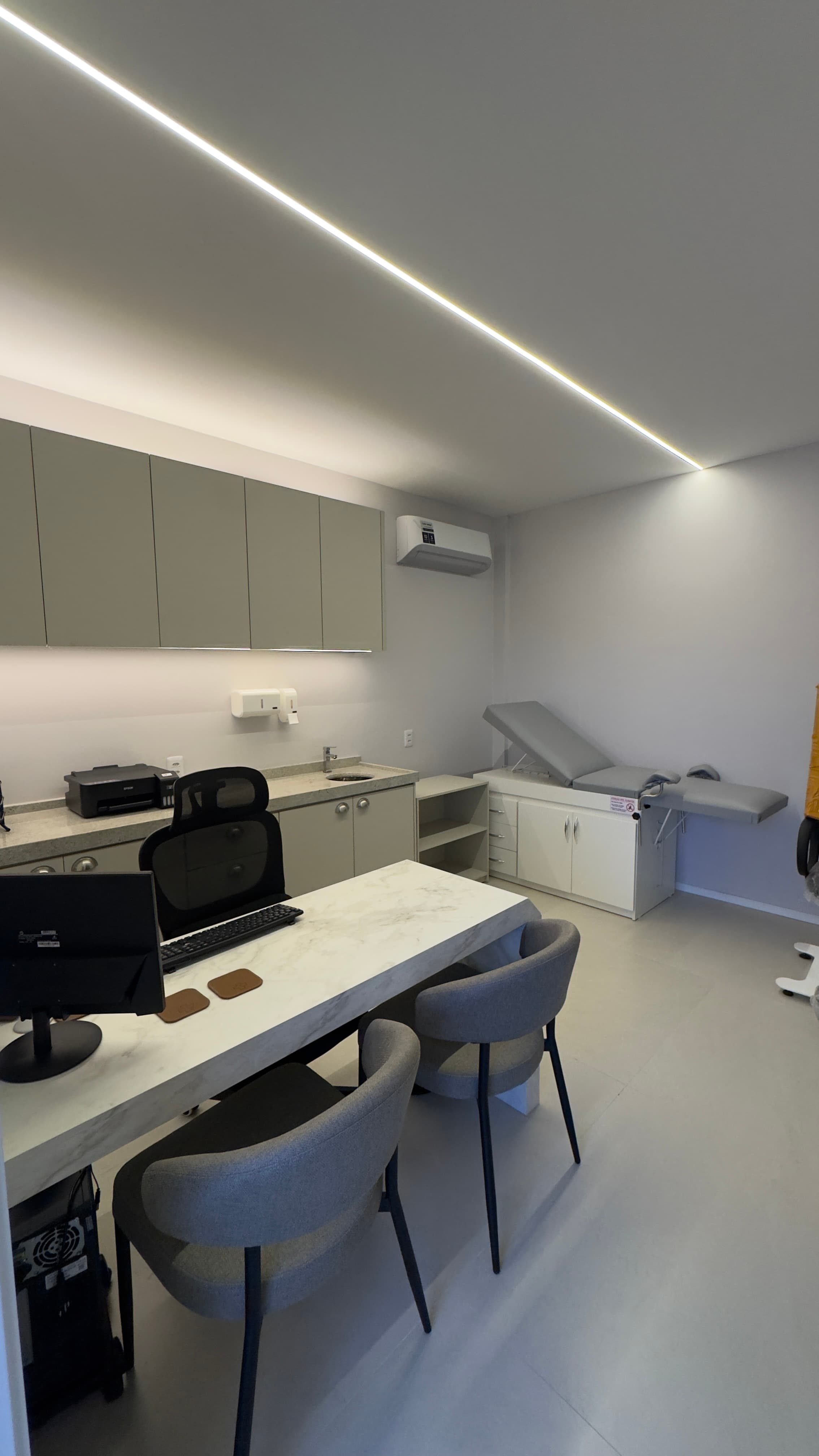 Consultório médico com mesa de exame e equipamentos modernos