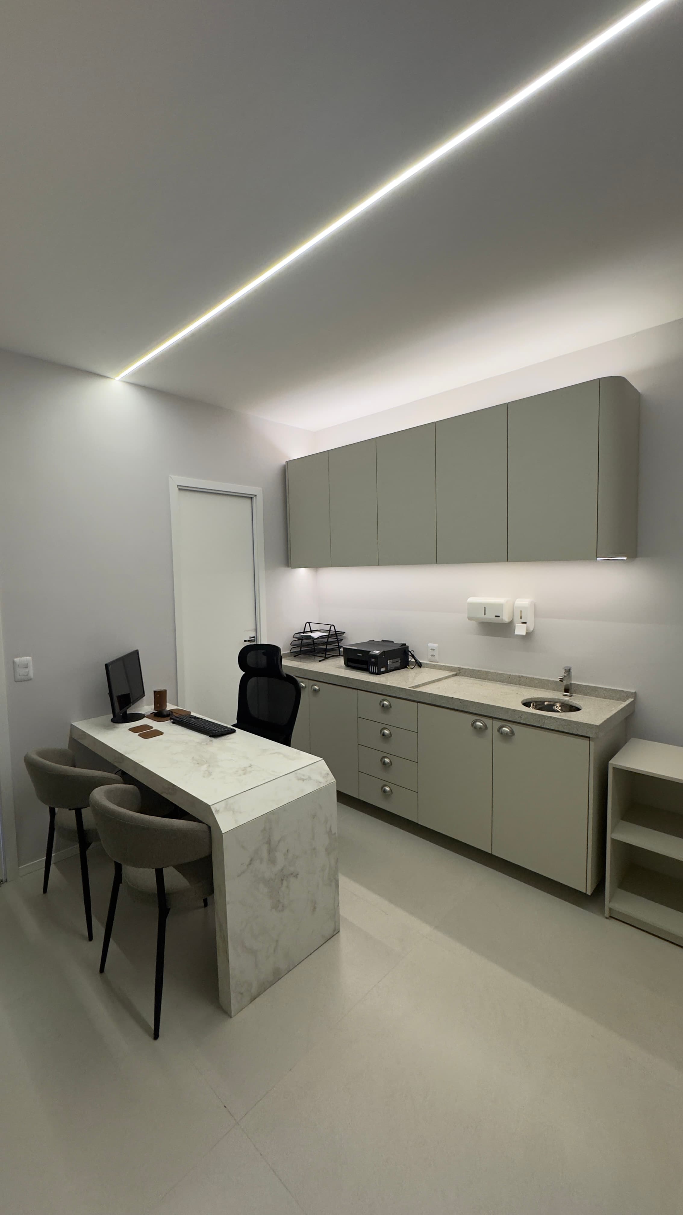 Consultório médico amplo com bancada e computador